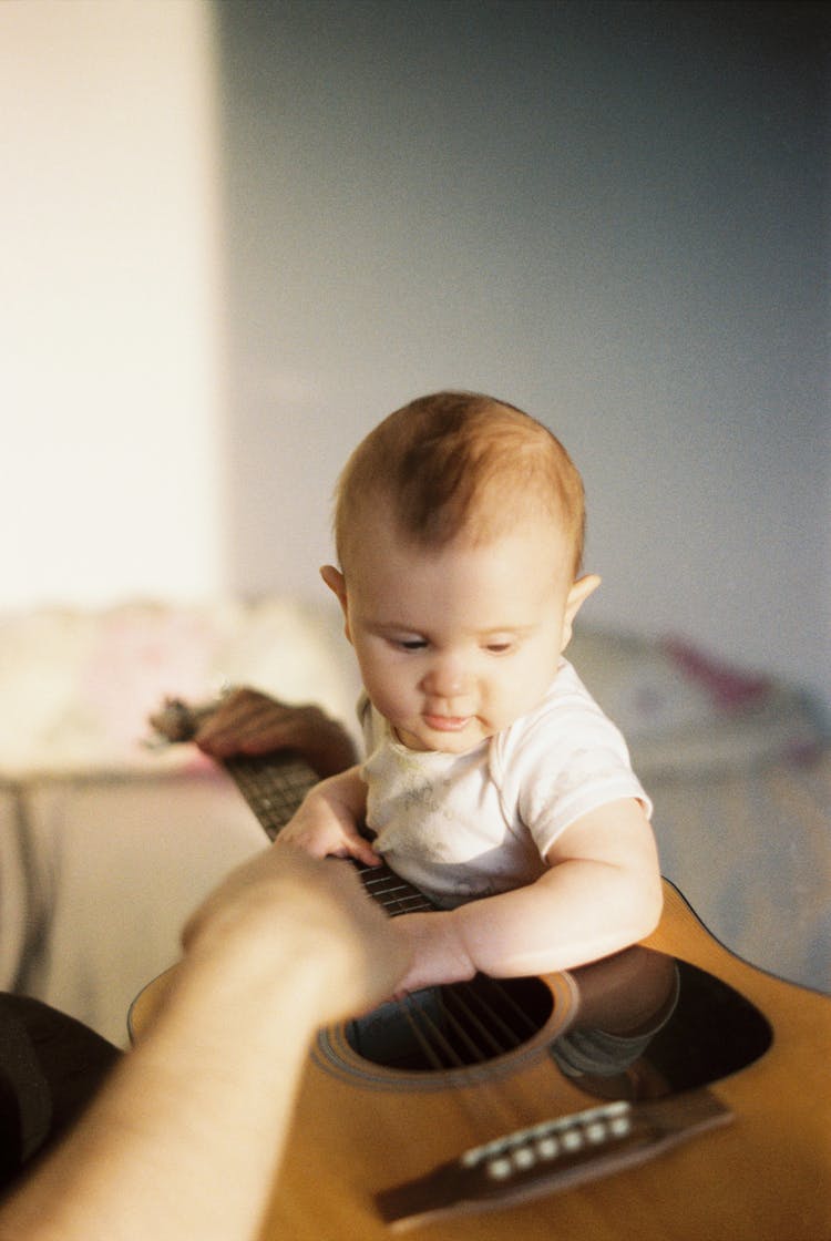 Baby Boy Holding A Guitar