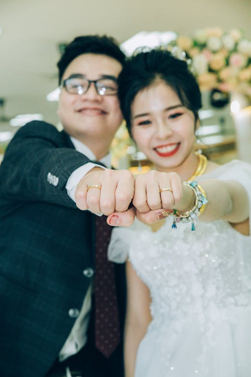 Delighted newlywed couple showing wedding rings