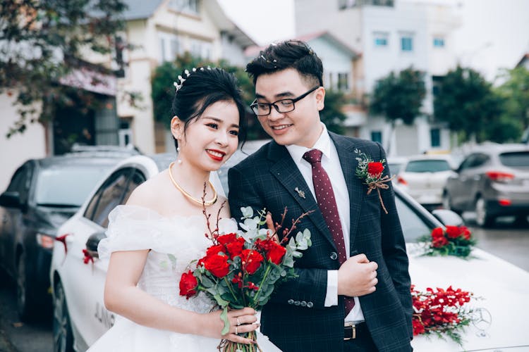 Happy Elegant Asian Couple Near Car On Wedding Day