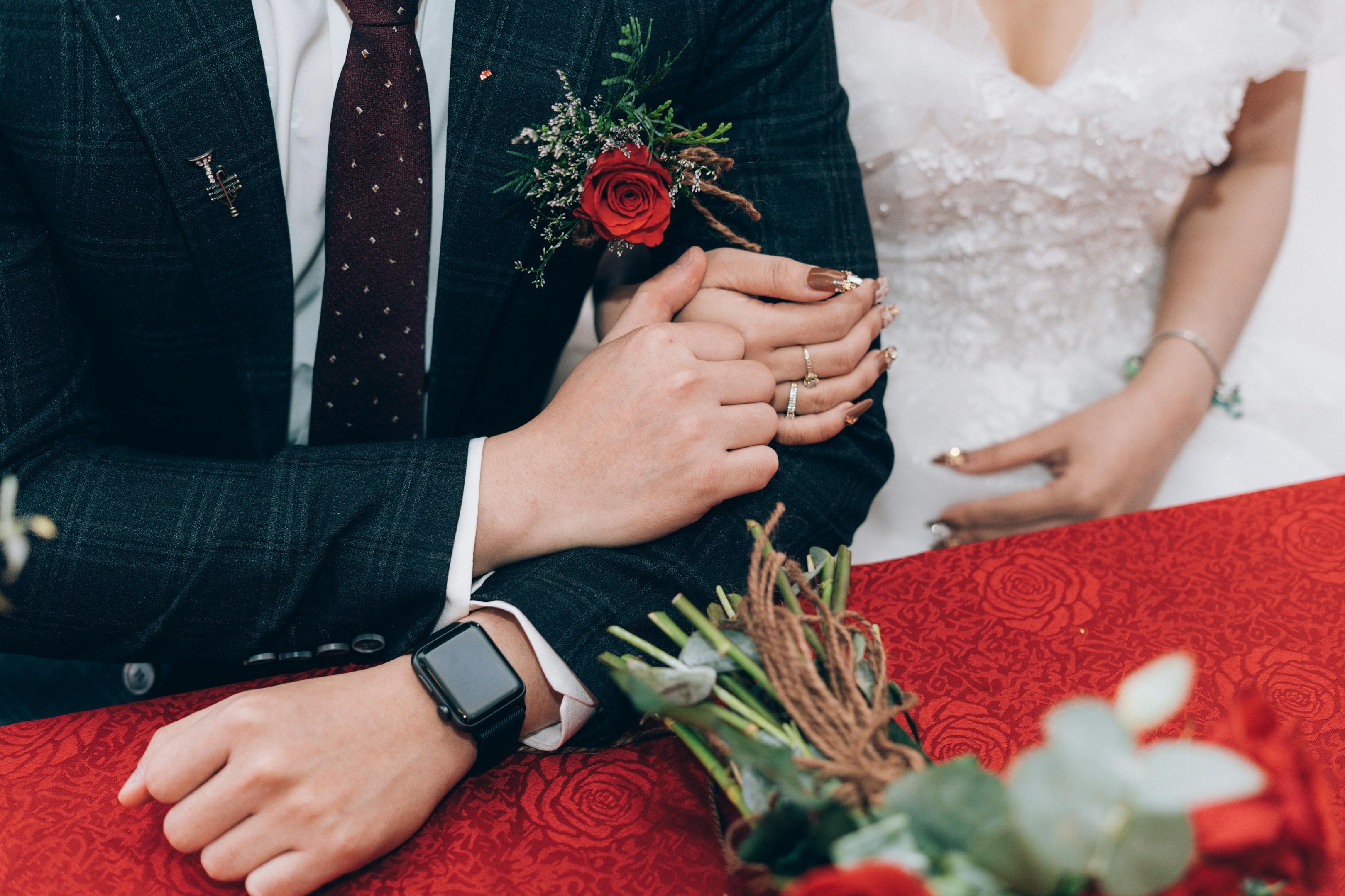 Crop stylish newlyweds sitting at table during wedding ...