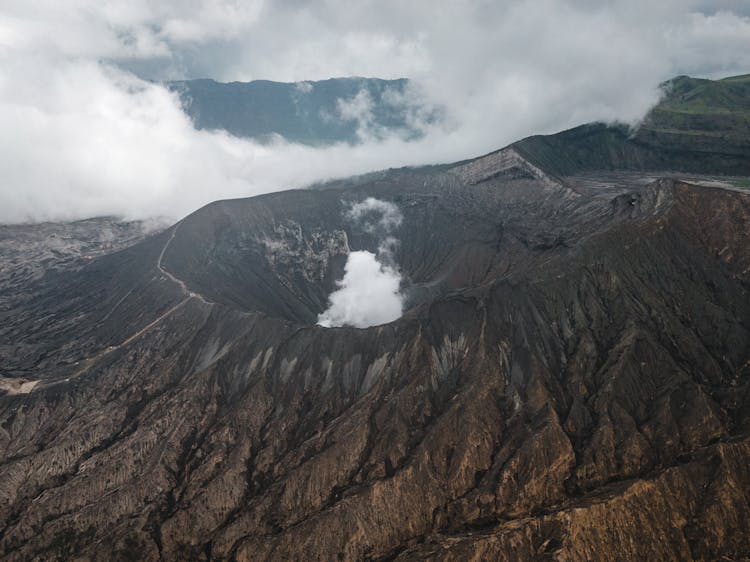 Dormant Volcano Near Mounts On Foggy Day