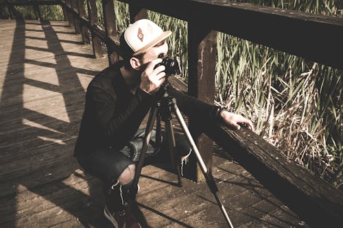 Person Standing Near Camera With Tripod