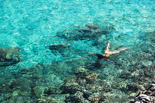 Free A woman snorkeling in crystal clear seawater, showcasing underwater scenery and vibrant marine life. Stock Photo