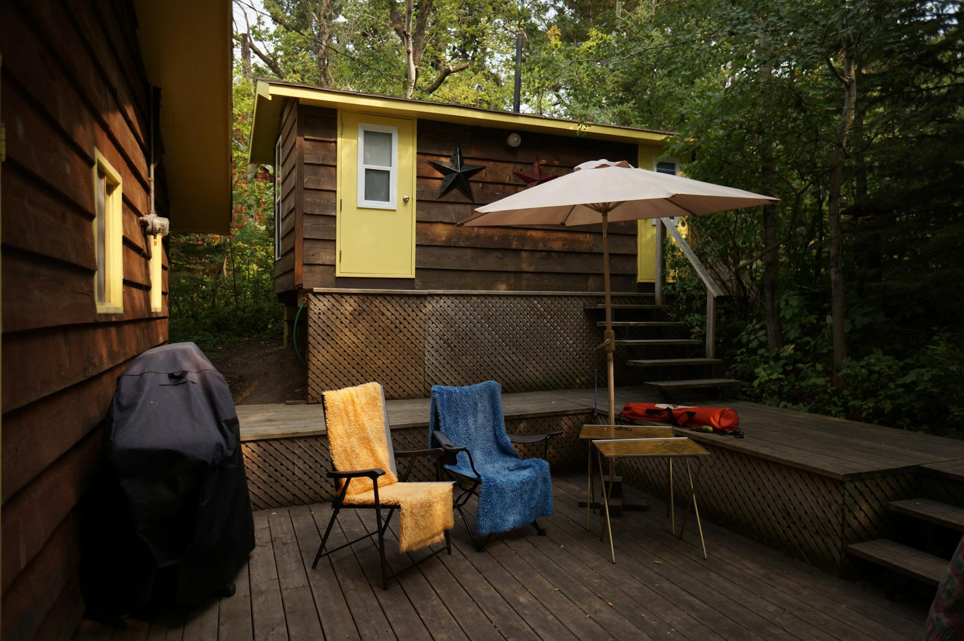 Charming cabin deck with chairs and umbrella at Wakaw Lake, SK.