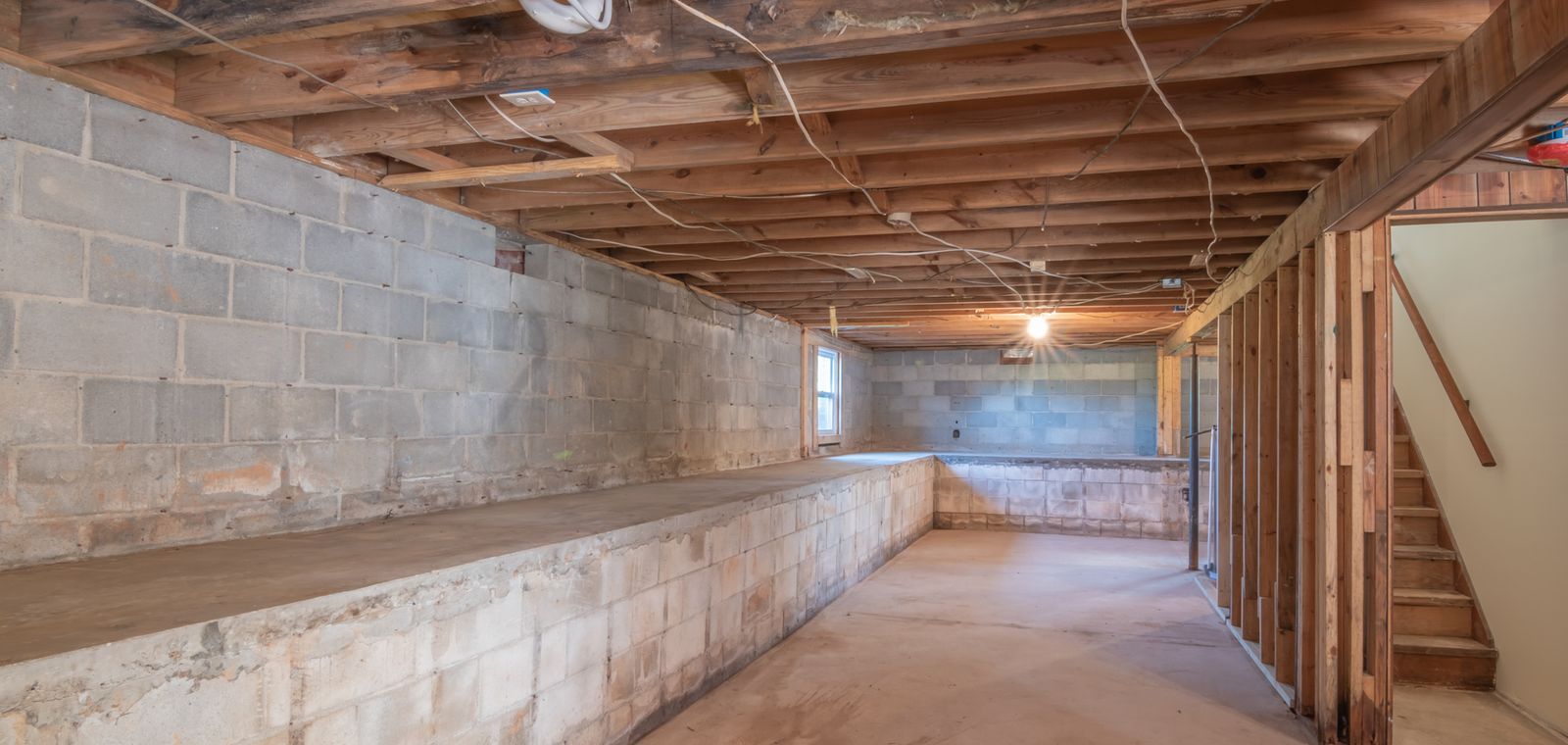 Basement with concrete walls and wooden beams