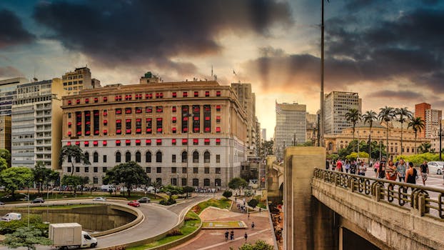 Panoramic view of São Paulo with striking architecture and vibrant sunset sky.