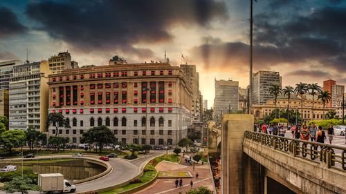 Free Picturesque view of old bridge above city road and house exteriors under bright cloudy sky in overcast weather at sundown in evening Stock Photo