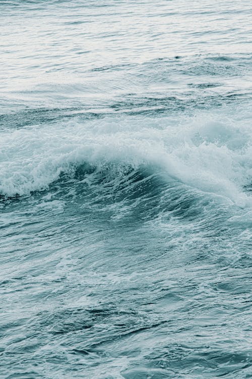 From above scenery view of seascape with splashing foamy water with ripples on surface in afternoon in stormy weather