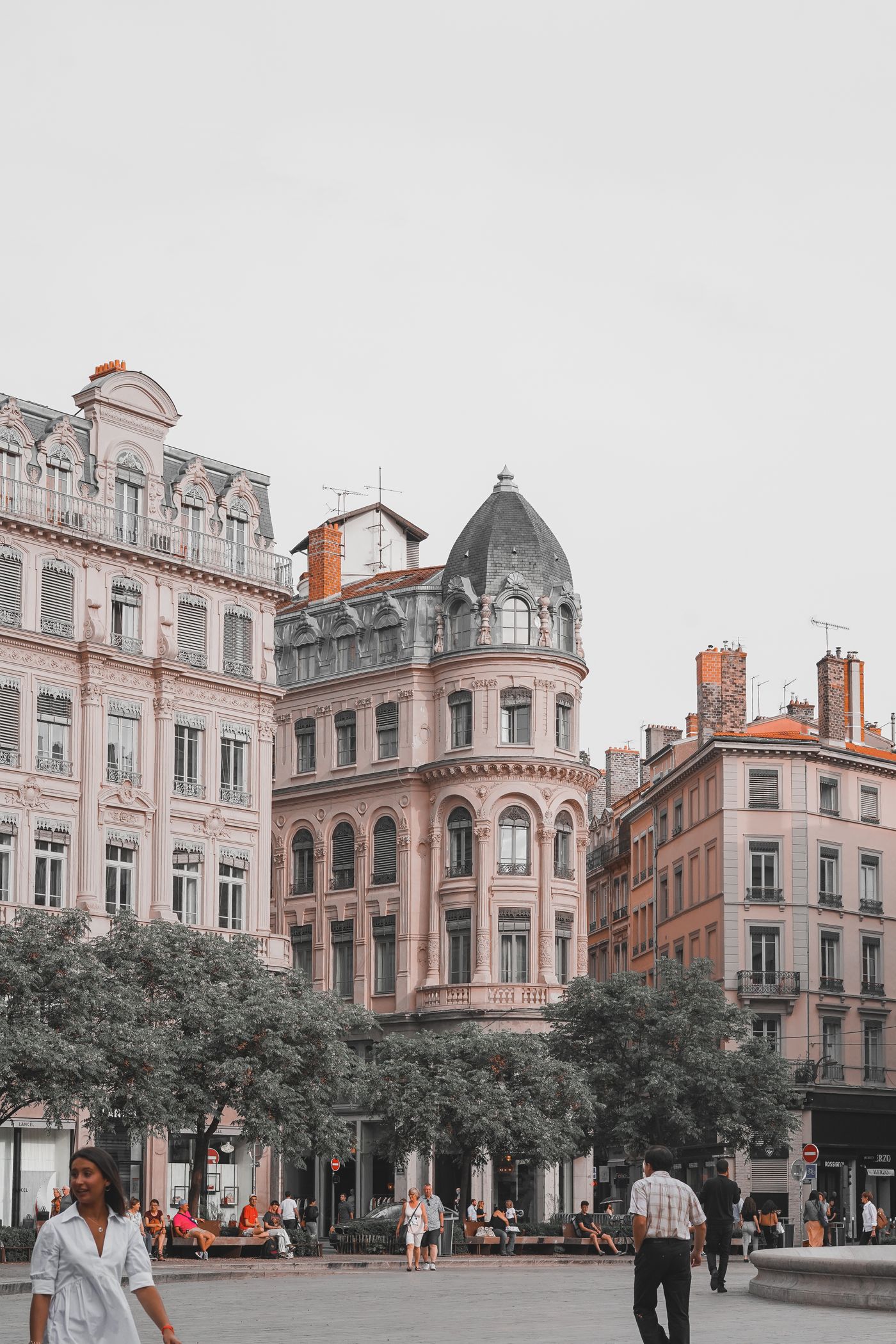Place animée entourée de bâtiments anciens à Lyon