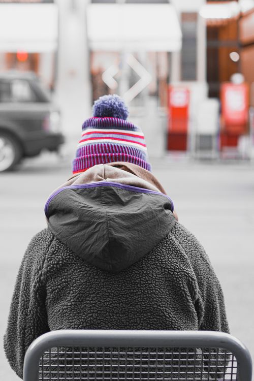 Free Back view of a person in winter attire sitting outdoors in Munich. Stock Photo