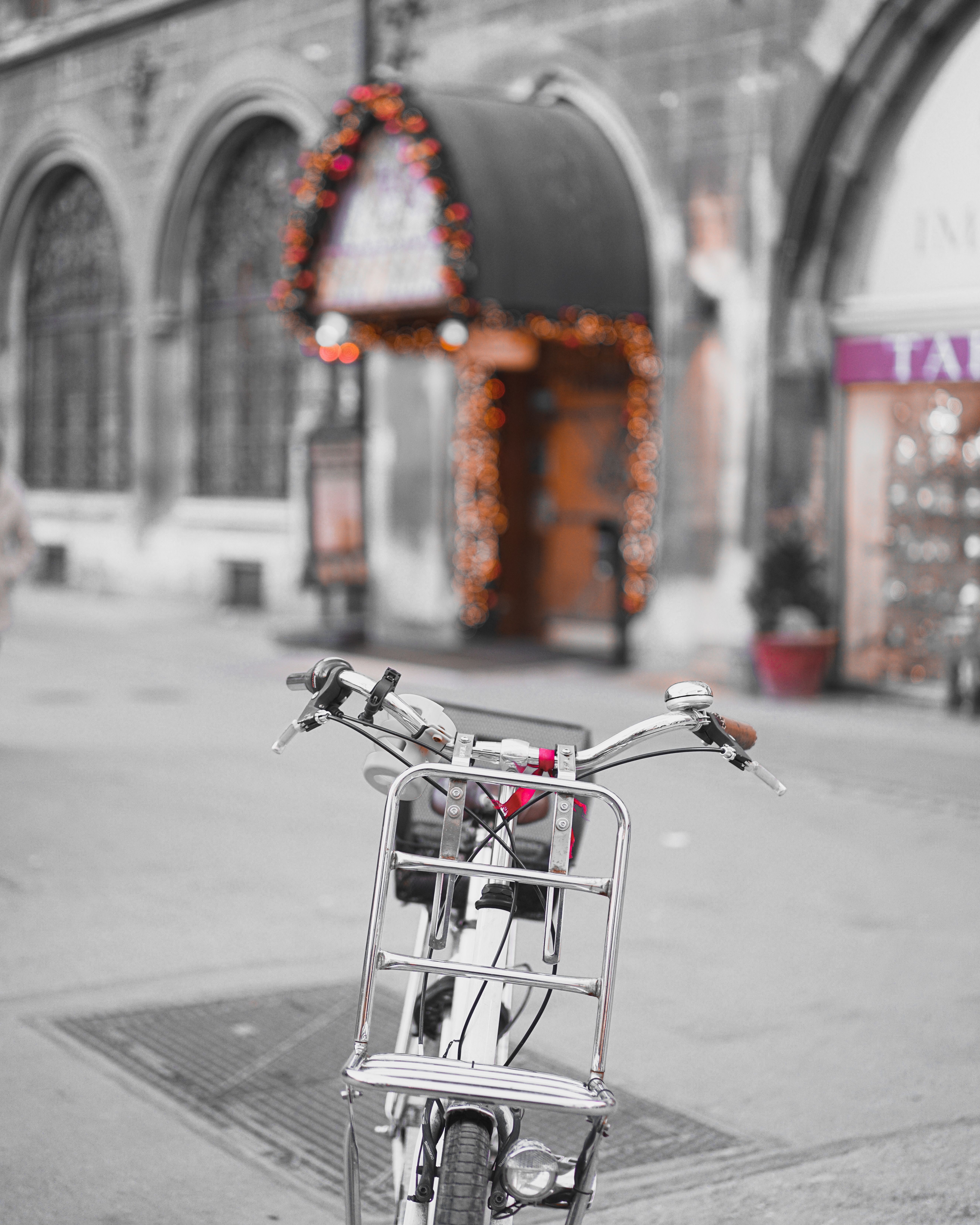 A bicycle parked on a charming street in Munich, adorned with festive lights.