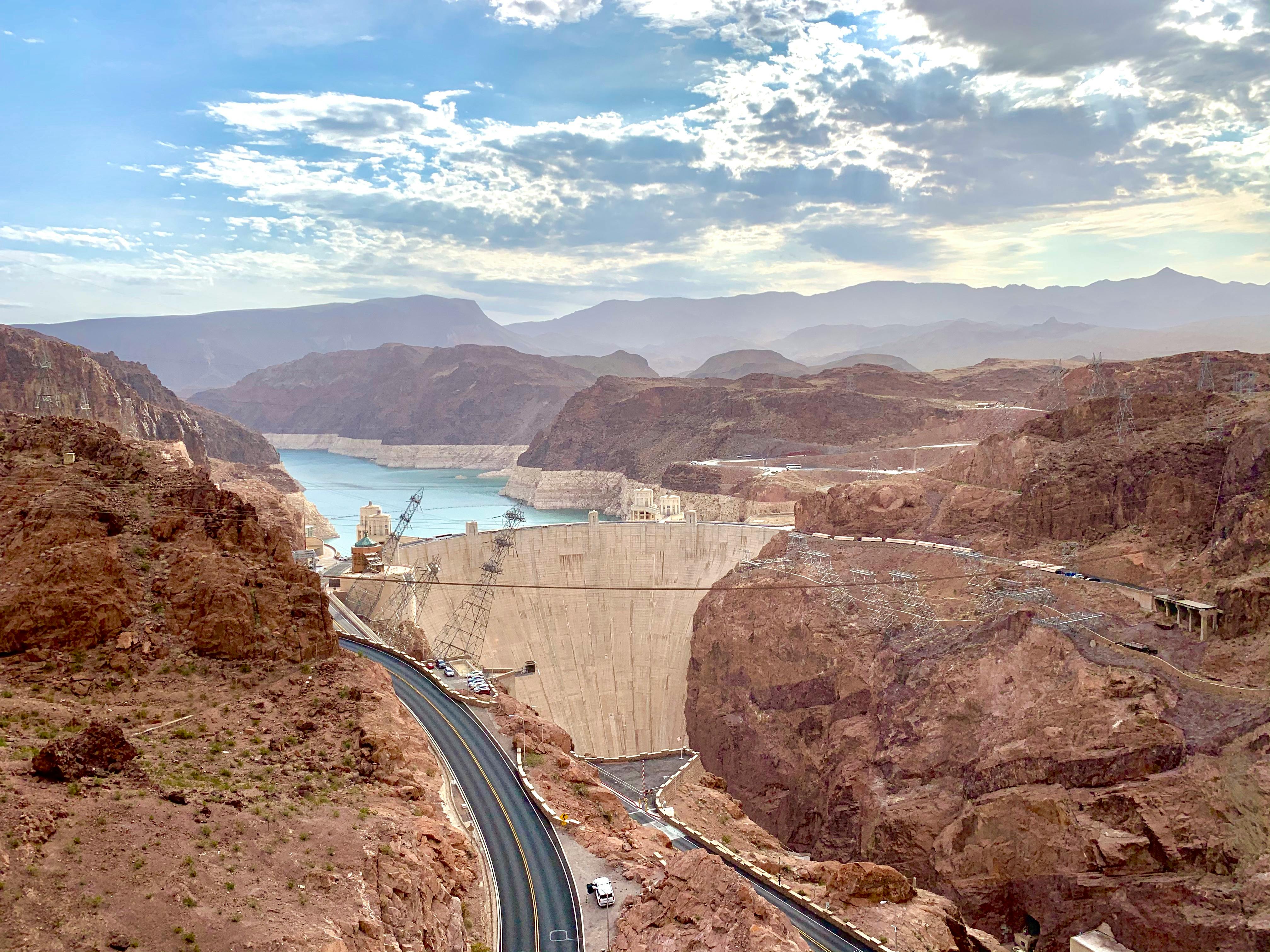 construction process in mountains near road and ocean under sky