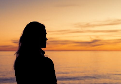 Silhouette of Woman Standing Near the Sea