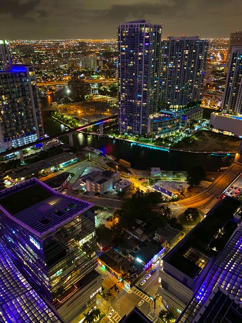 Free From above of contemporary megapolis with skyscrapers and house facades near road illuminated by artificial street light in evening Stock Photo