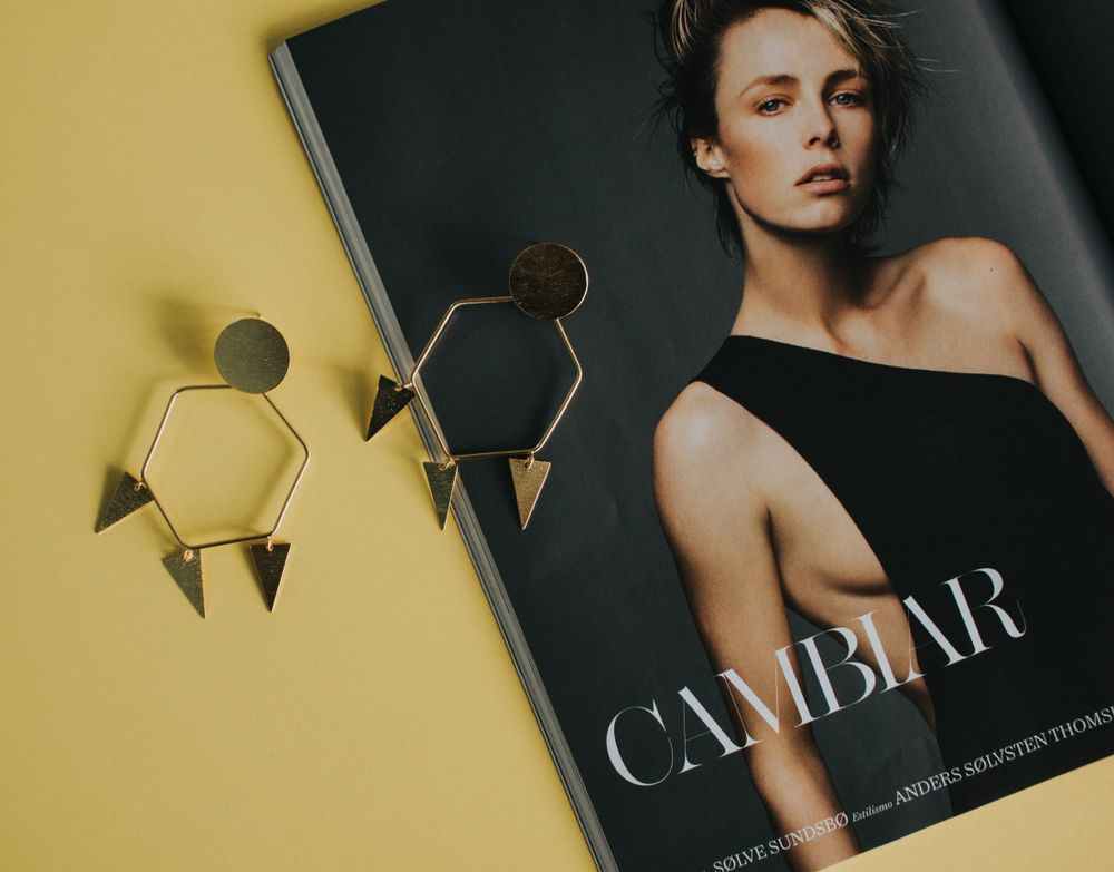 Gold drop earrings styled on a magazine