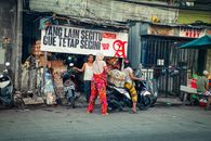 Busy street scene with a vendor and motorcycles in North Jakarta.