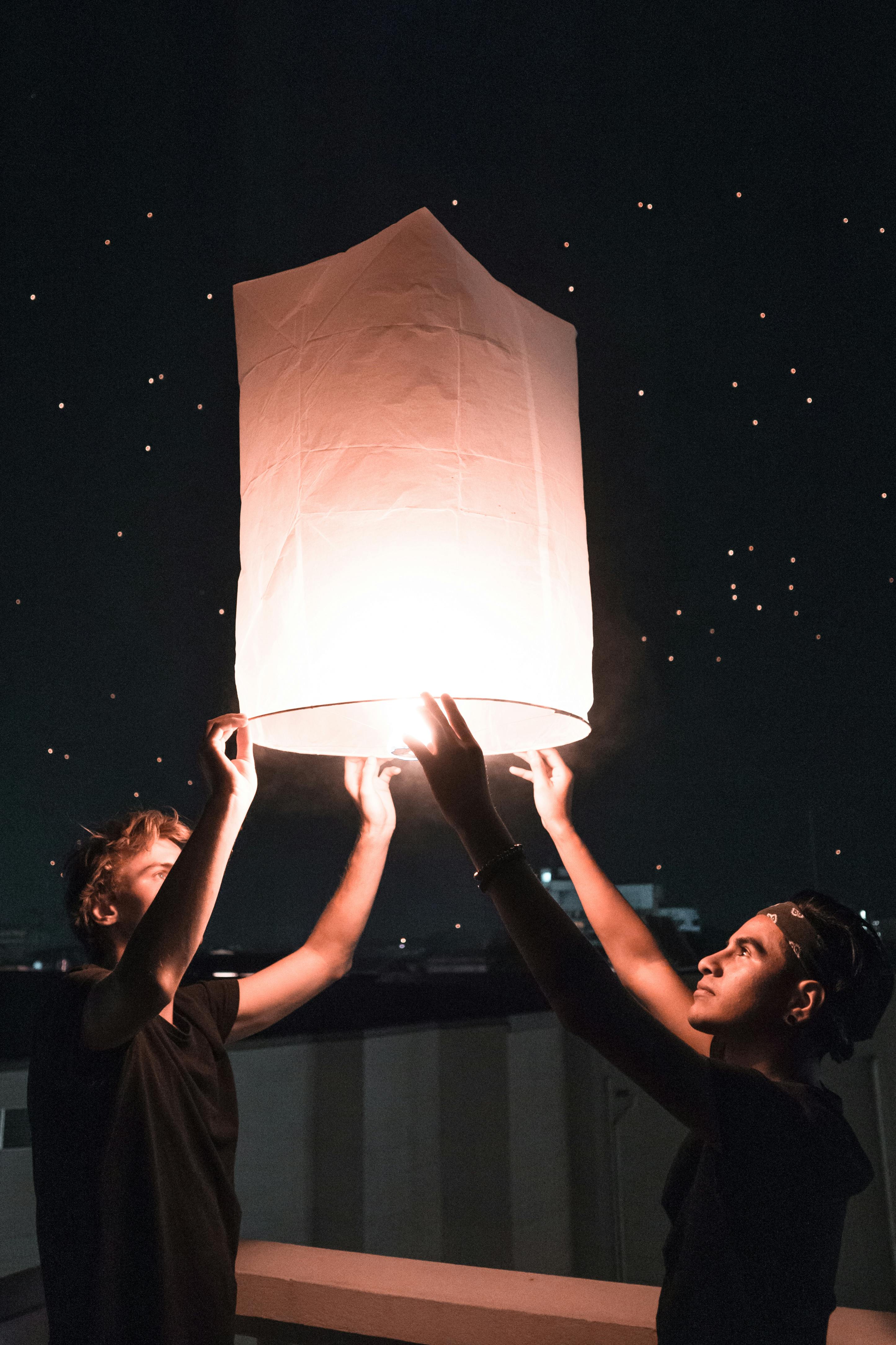 Sky Lantern Lighting by a Pair of Hands Holding the Paper Hot Air Balloon  in a Black Background Stock Image - Image of flame, fanush: 150374447