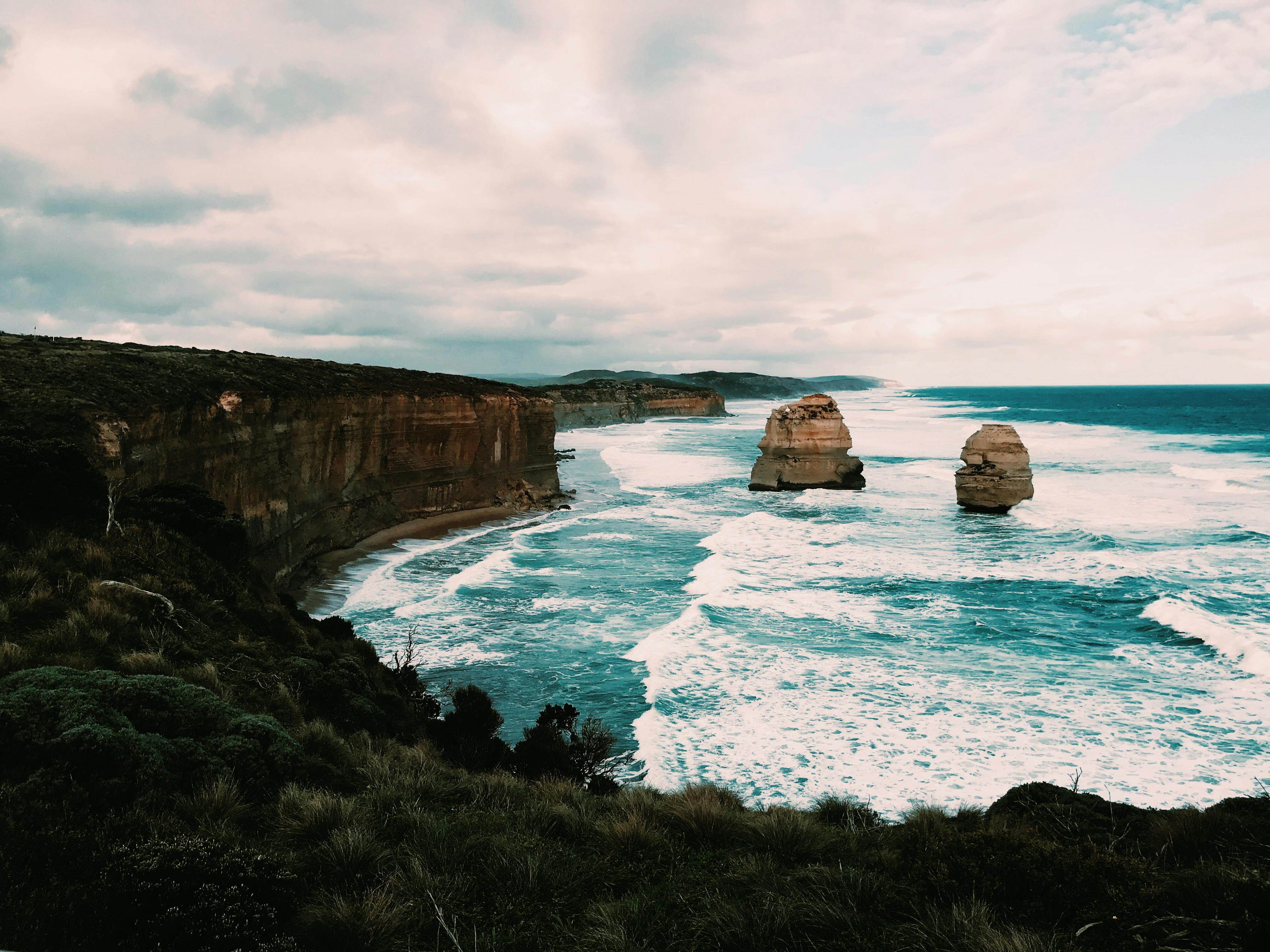 Turquoise sea coast surrounded by rocky cliff covered with lush trees ...