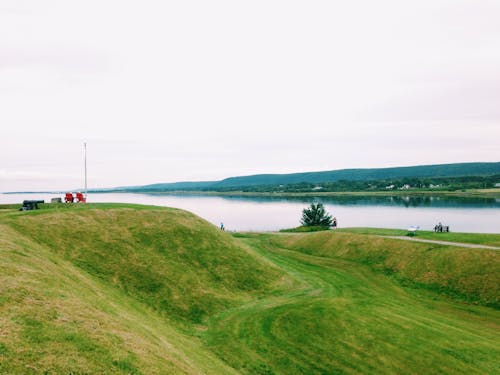 Green Grass Field Near Body of Water