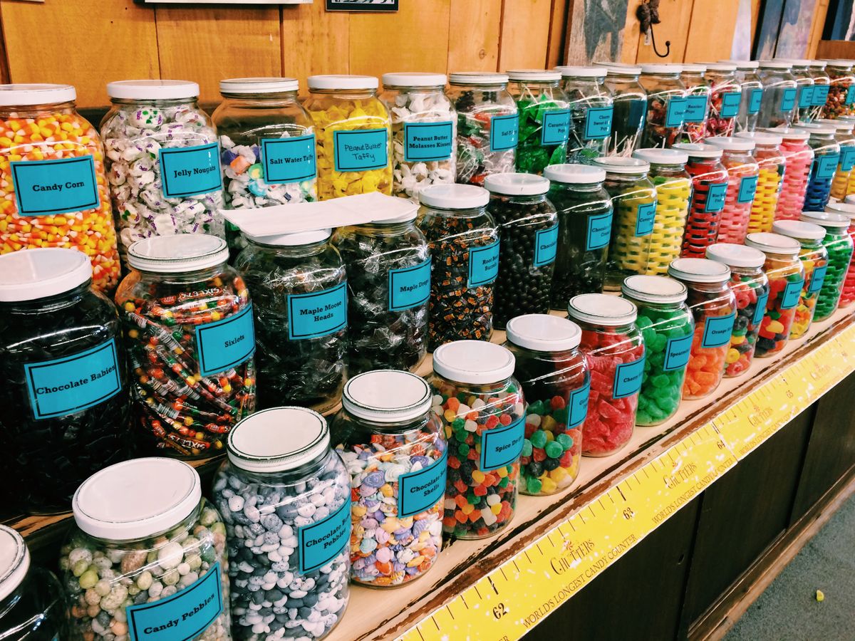 Assorted colorful retro candies stored in countertop glass jars