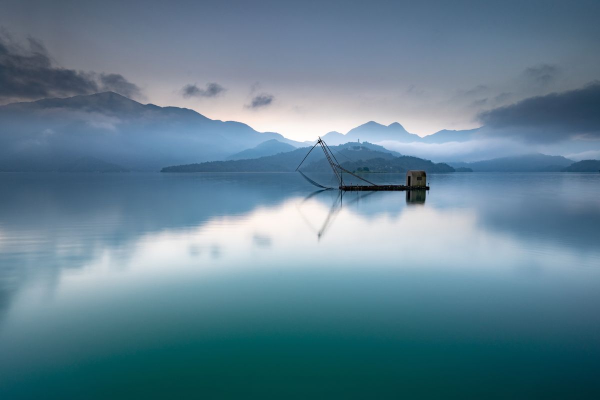 Traditional fish weir on the calm water of Sun Moon Lake at dawn