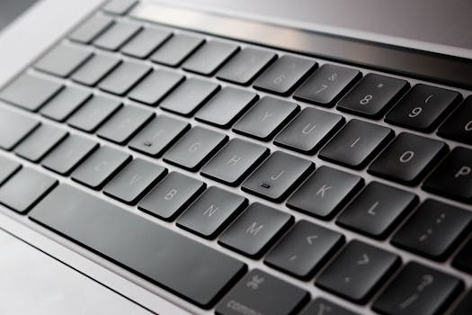 Detailed close-up of a modern laptop keyboard with sleek design and backlit keys.