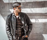 在伊利诺伊州斯普林菲尔德，一位穿着皮夹克、戴着太阳镜的时尚男子正在户外摆姿势