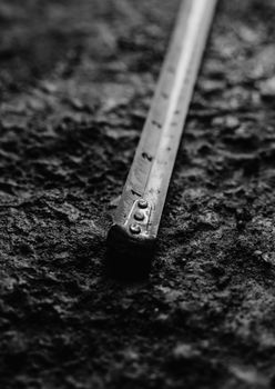 A black and white photo of a measuring tape laid out on a textured surface. Perfect for engineering concepts.