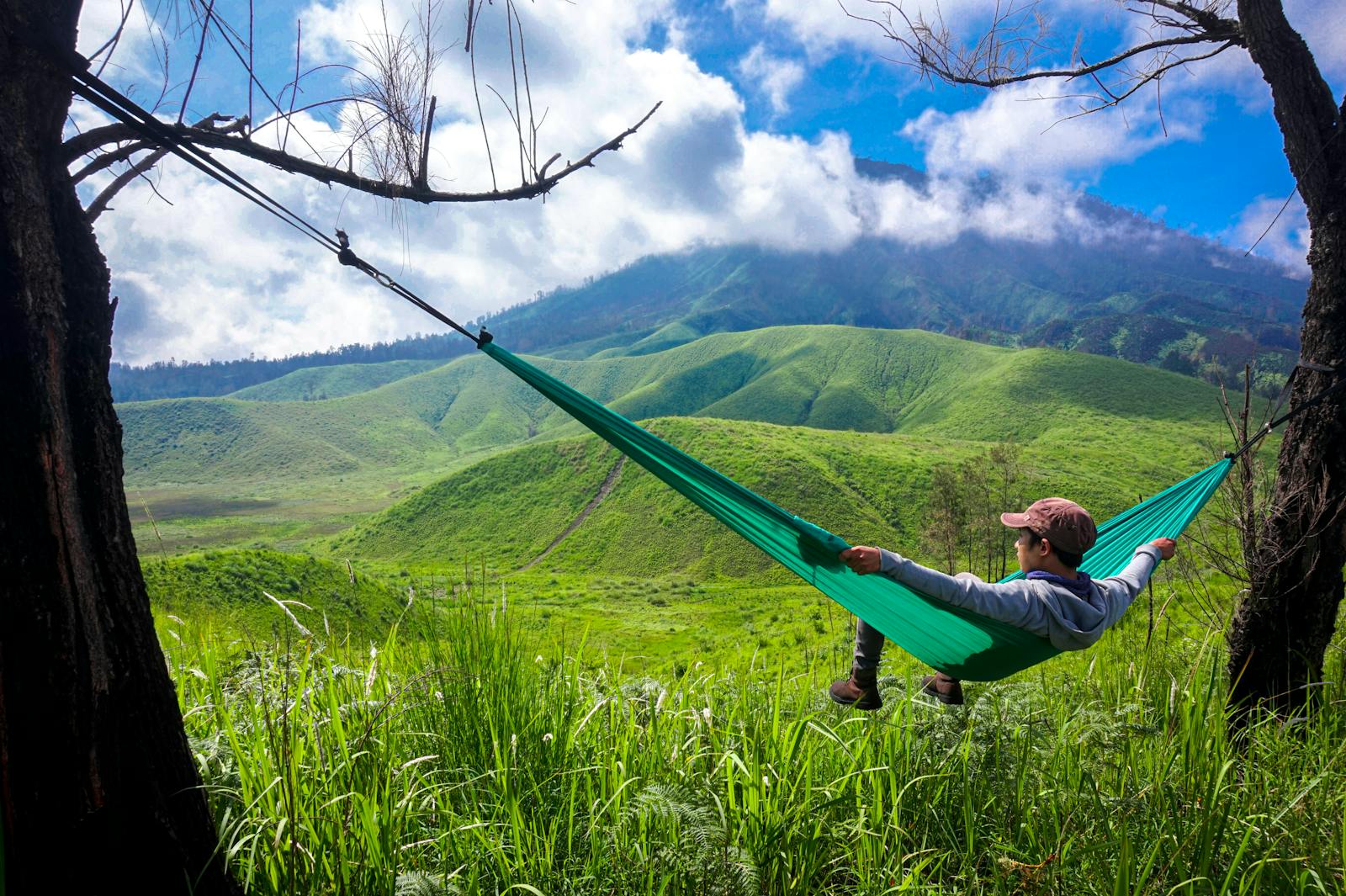 Man laying down on hammock admiring the view. 