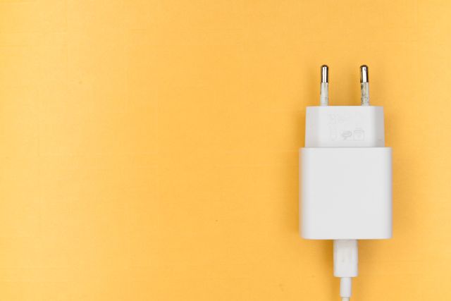 White two-pin charger on yellow background