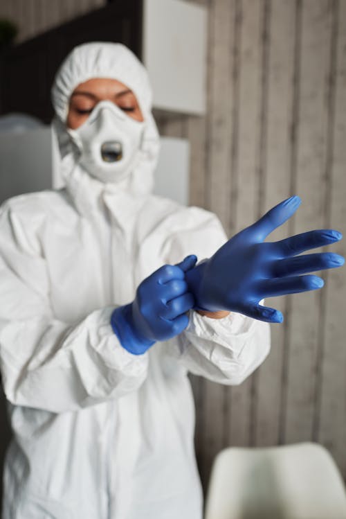 A Person in PPE Wearing Latex Gloves