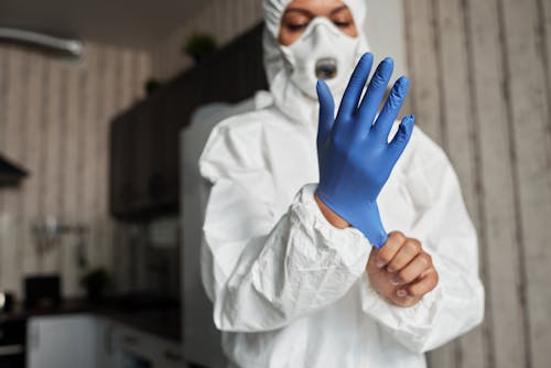 A Hand of a Person Wearing Latex Glove