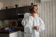 一名穿着个人防护装备的女子在厨房里拉上西装的拉链