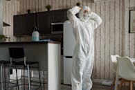 白天，在现代厨房环境中，站着身穿防护装备的人