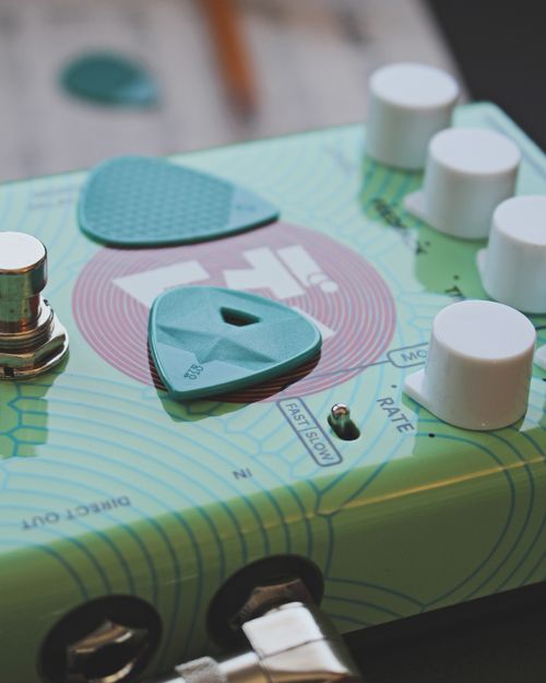 Free Close-up of colorful guitar pedal with teal guitar picks, showcasing music gear details. Stock Photo