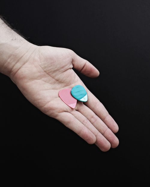 Free A hand holding colorful guitar picks on a dark background, perfect for music-related themes. Stock Photo