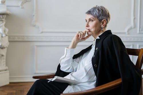 Man in Black Blazer Sitting on Chair