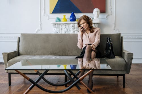 Woman in Brown Coat Sitting on Brown Wooden Chair