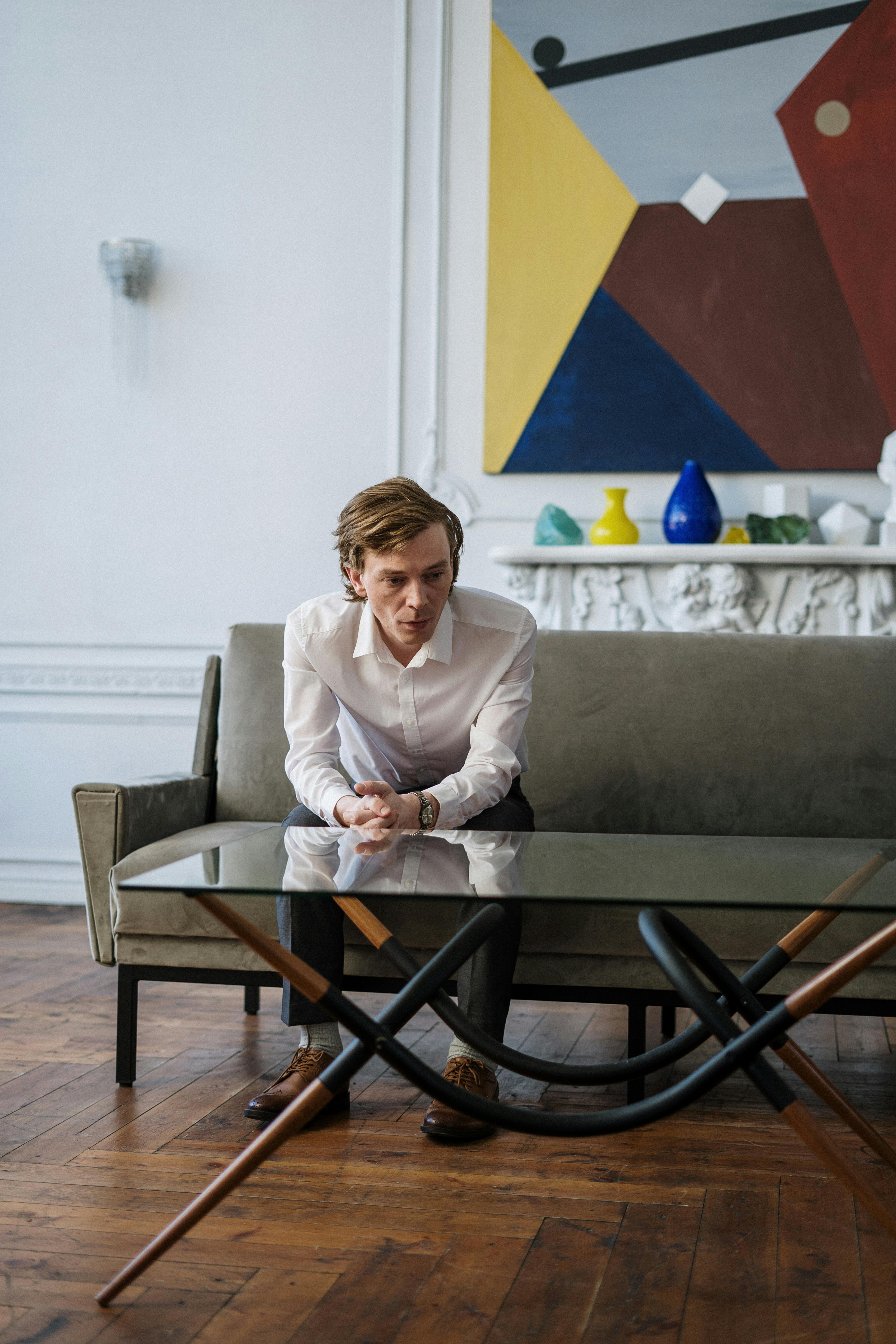 woman in white blazer sitting on gray couch