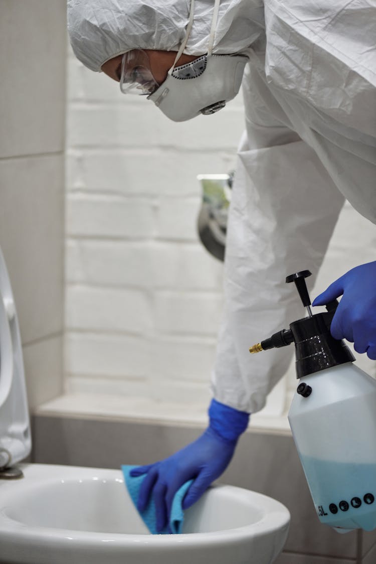 A Person Cleaning The Toilet Bowl