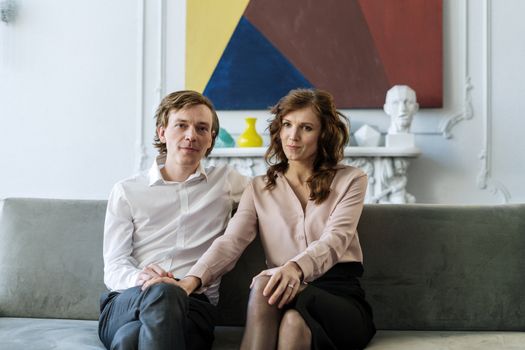 A couple sitting on a couch during a counseling session, showing connection and support.