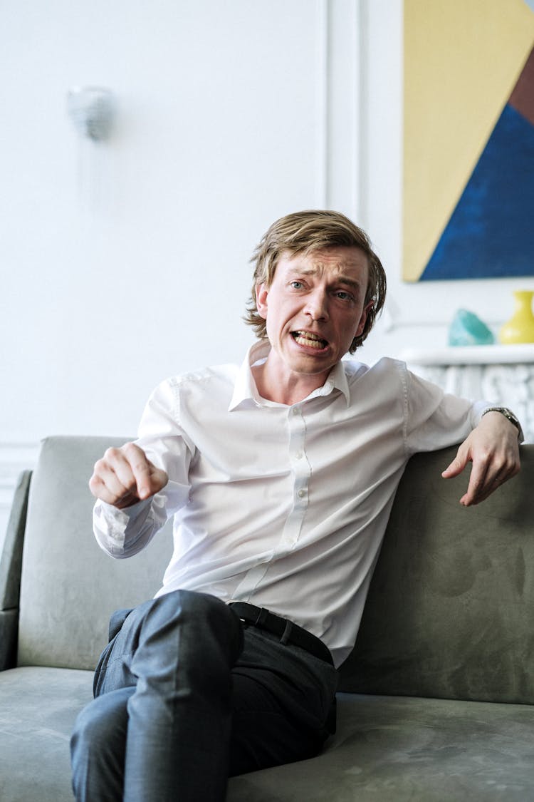 Man In White Dress Shirt Sitting On Gray Couch