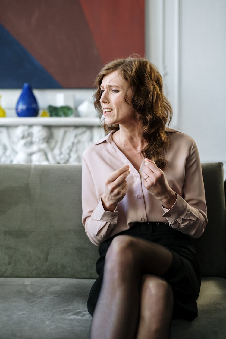 Woman In Pink Blazer Sitting On Couch