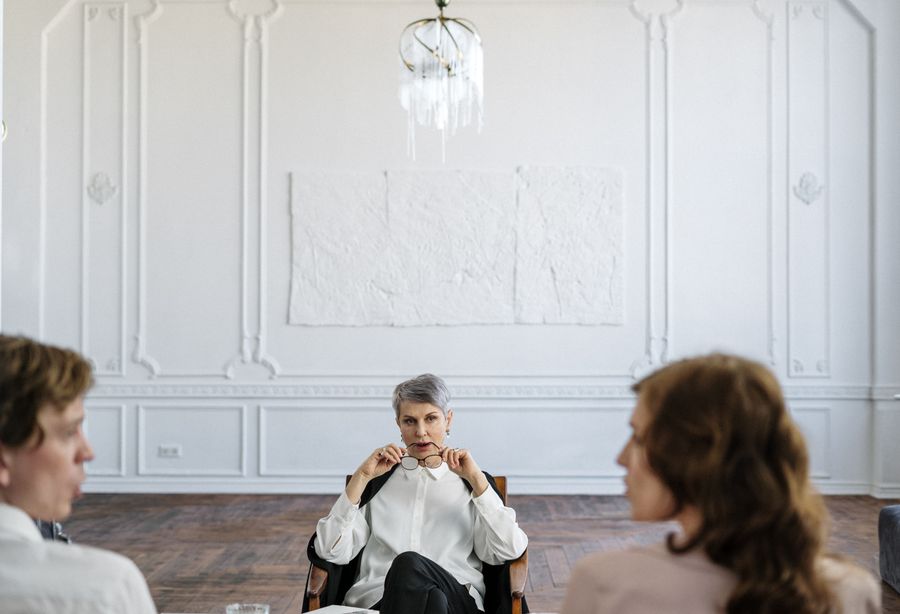 A couple in a counseling session with their therapist in an elegant office
