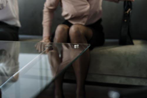 Woman in White Shirt and Black Shorts Sitting on Brown Wooden Bench