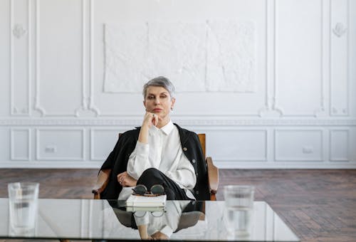 Man in Black Suit Sitting on Brown Wooden Chair