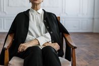 一位女士穿着职业装，坐在优雅的办公椅上