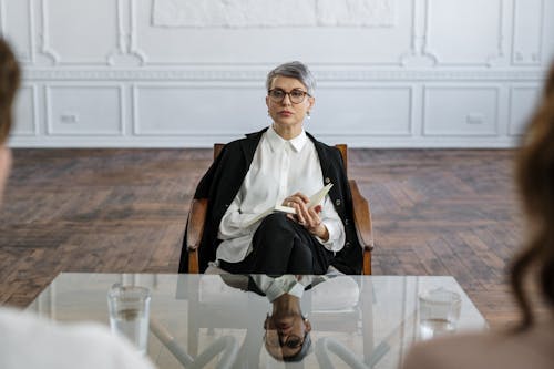 Man in Black Suit Sitting on Brown Wooden Chair