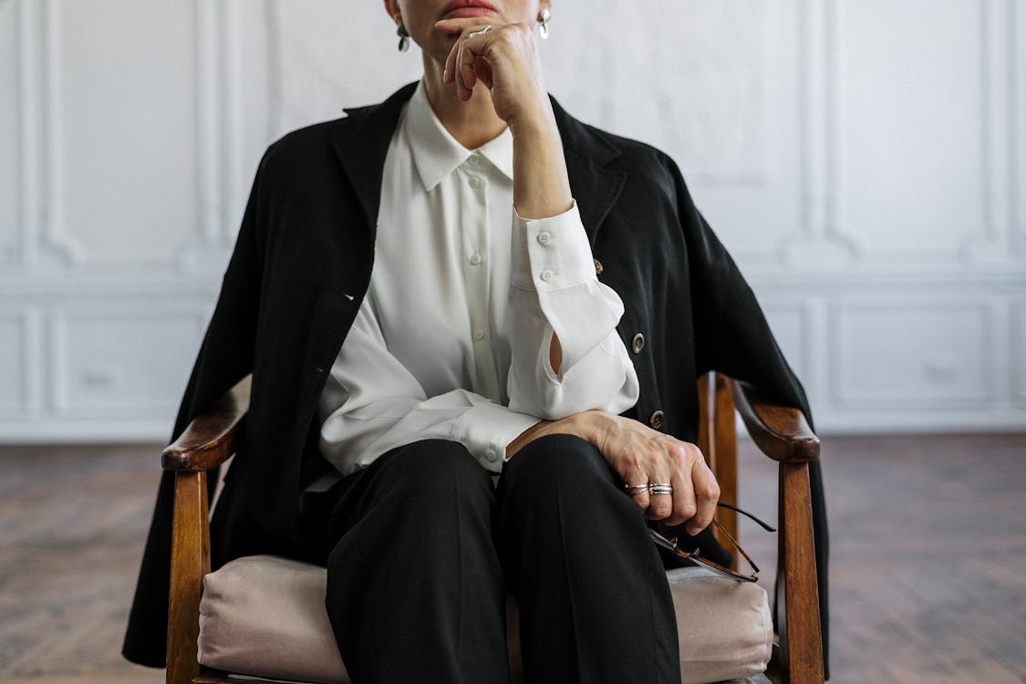 Man in Black Suit Sitting on Brown Wooden Armchair