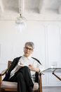 一位成熟的女性坐在现代化的办公室里，沉思着自己的想法